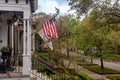 Charming home facades with flags in Savannah, Georgia on a cloudy day