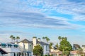 Charming homes and lush green trees with pale blue sky and gray clouds overhead