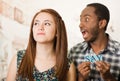 Charming interracial couple holding up small letters spelling the say while interacting happily, blurry studio Royalty Free Stock Photo