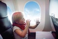 Charming kid traveling by an airplane. Little boy drinking water during the flight Royalty Free Stock Photo