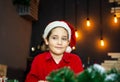 Charming kid in a Xmas cap on a colored background. Happy New Year