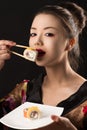 Charming Korean girl eating sushi rolls Royalty Free Stock Photo