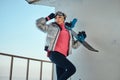 Charming lady with snowboard is posing for photographer