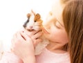 Charming little girl holding guinea pig near her cheek Royalty Free Stock Photo