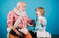 Charming little boy examining a cheek of his grandfather. Smiling grandfather and his grandson playing with a