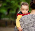 A charming little boy looks over his mother`s shoulder. Royalty Free Stock Photo