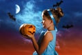 Charming little girl in a costume of the Cinderella princess holds a pumpkin on the background of the Royalty Free Stock Photo