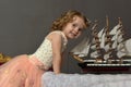 Charming little girl in elegant white with a pink dress sitting Royalty Free Stock Photo