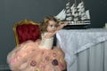 Charming little girl in elegant white with a pink dress sitting Royalty Free Stock Photo