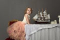 Charming little girl in elegant white with a pink dress sitting Royalty Free Stock Photo