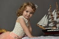 Charming little girl in elegant white with a pink dress sitting Royalty Free Stock Photo