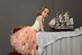 Charming little girl in elegant white with a pink dress sitting Royalty Free Stock Photo