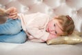 Charming little girl falls asleep on a pink sofa. Royalty Free Stock Photo