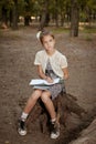 Charming little girl in forest with book Royalty Free Stock Photo