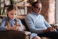Charming little girl and grandfather demonstrating Internet addiction indoors Royalty Free Stock Photo