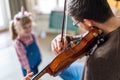 Charming little girl learning to play the violin with an artistic music teacher. Royalty Free Stock Photo