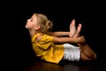 Cute little girl lying on the floor in the studio on a black background Royalty Free Stock Photo