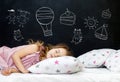 Charming little girl of preschool age sleeps in bed on a pillow with stars. Time to sleep. Drawing about the dreams of a