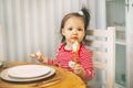 Charming little girl sitting at the table with a spoon in her hand waiting for Christmas DINNER. Royalty Free Stock Photo