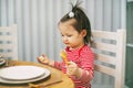 Charming little girl sitting at the table with a spoon in her hand waiting for Christmas DINNER. Royalty Free Stock Photo