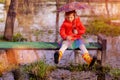 Little girl with umbrella on bench in puddle Royalty Free Stock Photo