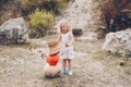 Charming little girl in a straw hat, wicker chair, pumpkins