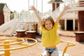 A charming little girl is walking in the park, swinging on a swing. Happy childhood, playtime Royalty Free Stock Photo