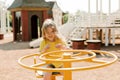 A charming little girl is walking in the park, swinging on a swing. Happy childhood, playtime Royalty Free Stock Photo