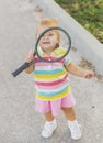 Charming little tennis player covered by racket