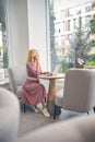 Dreamy blonde woman looking at big window Royalty Free Stock Photo