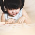 Charming and lovely asian kid concentrated on reading book