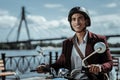 Charming male student going to classes on motorbike