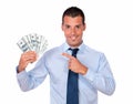 Charming man holding and pointing his dollars