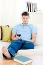 Charming man holding a wineglass on the sofa Royalty Free Stock Photo