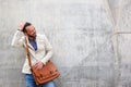 Charming man with leather bag standing against wall Royalty Free Stock Photo