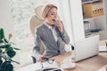 Charming, mature, middle age woman in jacket sitting at her desk Royalty Free Stock Photo