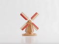 A charming miniature Dutch windmill with red and tan sails on a Isolated on white {Ai generated Royalty Free Stock Photo