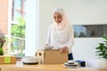 Charming muslim woman small online business owner packing her product to ship