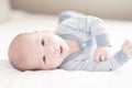 Charming newborn baby boy in blue on a bed