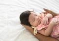 Cute Asian newborn baby girl sleeping on dad hand. Father nursing his infant with love on bed at home. Love and new life concept Royalty Free Stock Photo