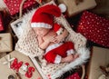 Charming newborn sleeping between christmas presents