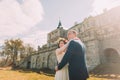 Charming newlywed bride and groom embracing near beautiful ruined baroque palace Royalty Free Stock Photo