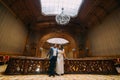 Charming newlywed pair embracing while leaning on balustrade at gorgeous antique stairs with the background of royal