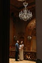 Charming newlywed pair holding hands at the background of vintage victorian mansion royal wooden interior Royalty Free Stock Photo