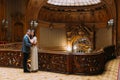 Charming newlywed pair leaning one to another at the background of vintage victorian mansion royal wooden interior Royalty Free Stock Photo