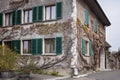 Old house with green shutters covered in vines in a Swiss village. Royalty Free Stock Photo