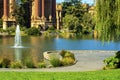 Charming park with winding sidewalk path for walkong the dog in outdoor area with lake and waterfountain spout Royalty Free Stock Photo