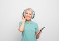 Charming pensioner wearing wireless headphones.