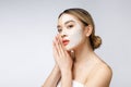 Charming pleasant woman applying cream on half face. Royalty Free Stock Photo