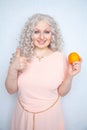 Charming plump curly blonde in pink dress with orange on white solid studio background alone